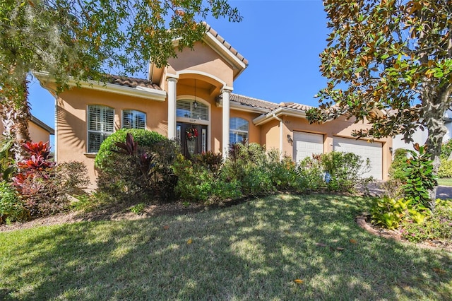 mediterranean / spanish house with a front yard and a garage