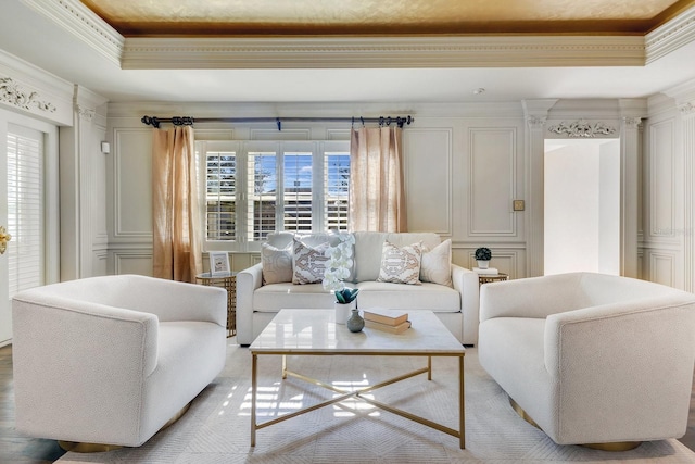 living room with plenty of natural light, ornate columns, ornamental molding, and a raised ceiling