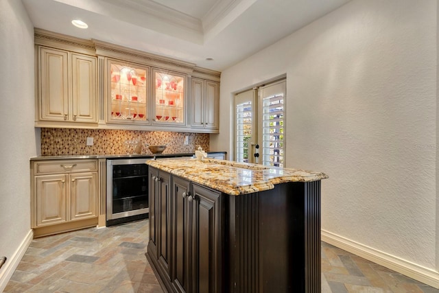 bar featuring wine cooler, backsplash, light stone countertops, ornamental molding, and cream cabinetry