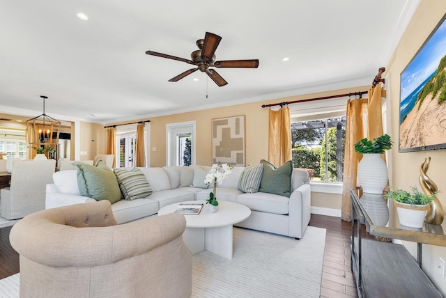 living room featuring ceiling fan with notable chandelier, crown molding, and light hardwood / wood-style floors