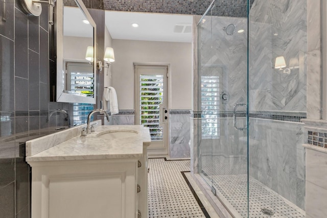 bathroom featuring tile walls, a shower with shower door, and vanity