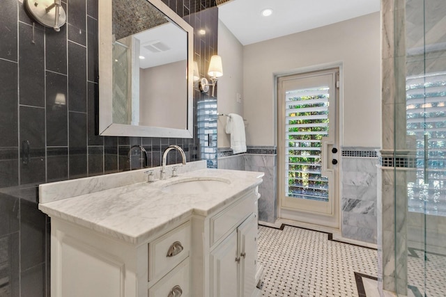 bathroom with tile walls, walk in shower, and vanity