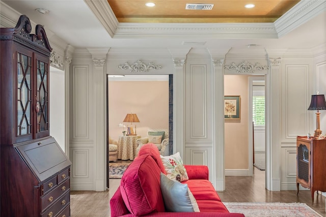 sitting room with crown molding, a tray ceiling, and light hardwood / wood-style floors