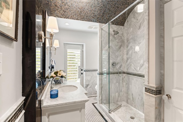 bathroom featuring toilet, a shower with door, tile patterned floors, and vanity