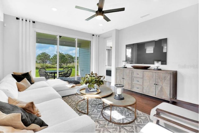 living room with ceiling fan and dark wood-type flooring