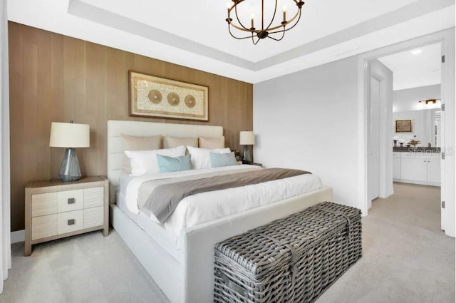 bedroom featuring ensuite bathroom, light carpet, wood walls, and a notable chandelier