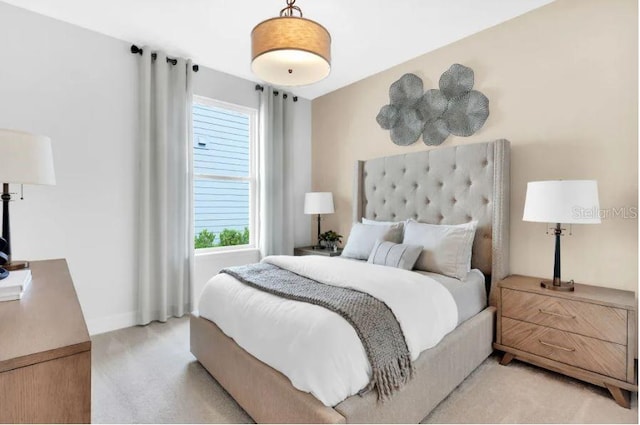 bedroom featuring light colored carpet and multiple windows