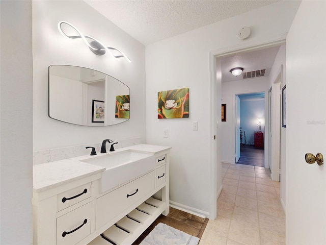 bathroom featuring tile patterned floors, vanity, and a textured ceiling