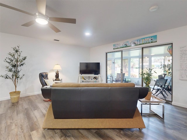 living room featuring hardwood / wood-style floors and ceiling fan