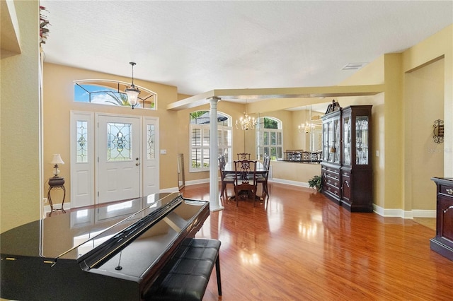 foyer entrance with a chandelier, hardwood / wood-style floors, a healthy amount of sunlight, and a textured ceiling