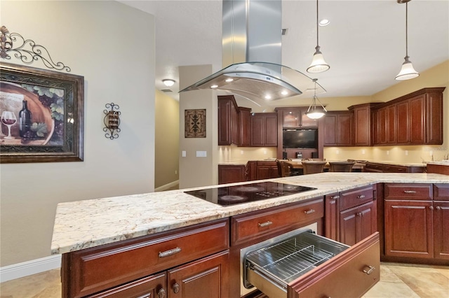 kitchen featuring island exhaust hood, light stone countertops, black electric cooktop, decorative light fixtures, and a center island