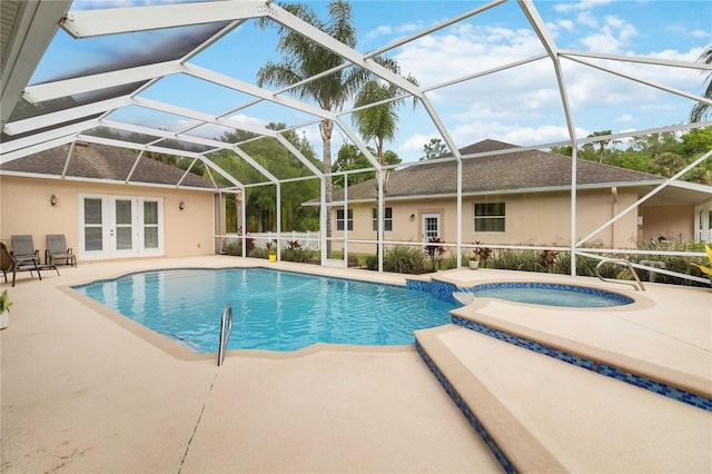 view of pool featuring glass enclosure, an in ground hot tub, a patio, and french doors