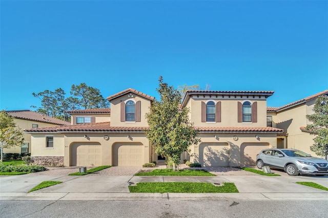 8169 Roseville Rd, Davenport, FL 33896 - mediterranean / spanish home featuring driveway, stucco siding, an attached garage, and a tile roof