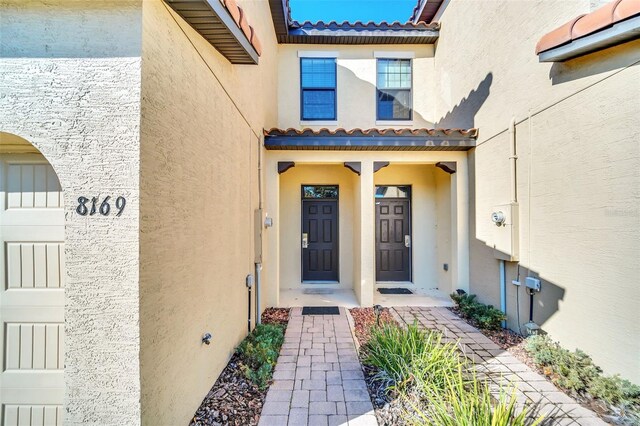 8169 Roseville Rd, Davenport, FL 33896 - doorway to property with a tiled roof and stucco siding