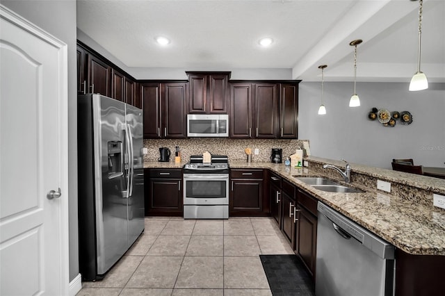 kitchen with sink, stainless steel appliances, kitchen peninsula, decorative light fixtures, and decorative backsplash