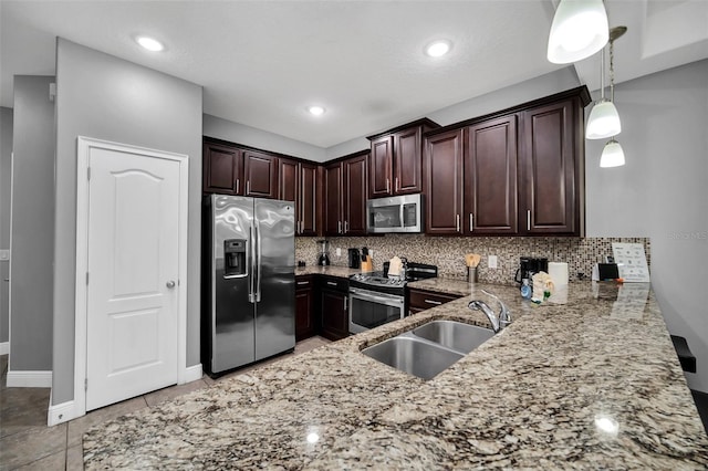 kitchen featuring sink, hanging light fixtures, backsplash, dark brown cabinets, and appliances with stainless steel finishes