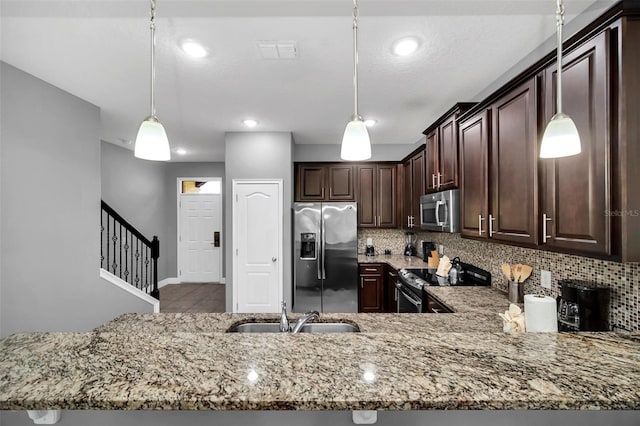 8169 Roseville Rd, Davenport, FL 33896 - kitchen with appliances with stainless steel finishes, light stone countertops, decorative backsplash, dark brown cabinetry, and hanging light fixtures