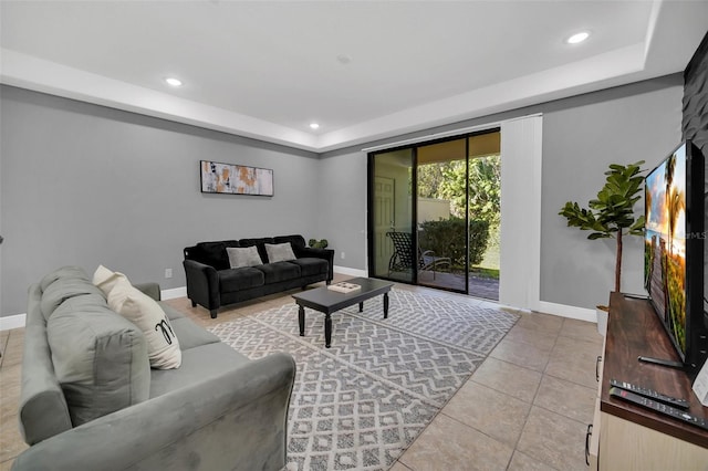 living room featuring light tile patterned floors and a tray ceiling