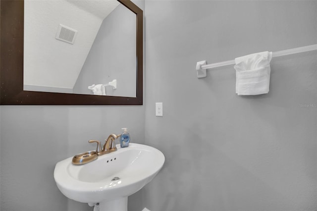 bathroom featuring sink and vaulted ceiling