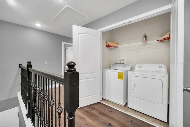 clothes washing area with washing machine and dryer, dark wood-type flooring, and a textured ceiling