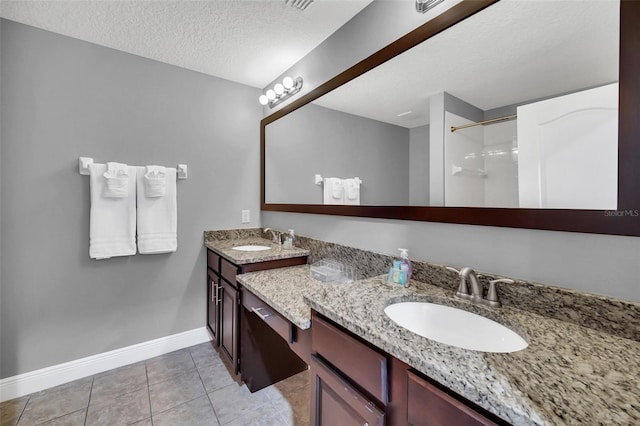 bathroom featuring a shower, tile patterned flooring, vanity, and a textured ceiling