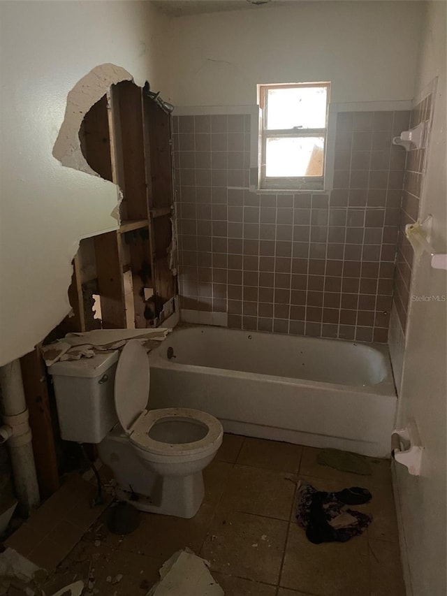 bathroom featuring tile patterned flooring, toilet, and a washtub