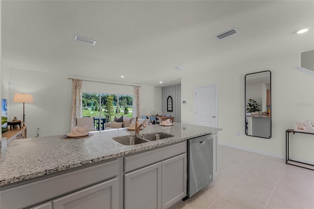 kitchen featuring stainless steel dishwasher, light stone counters, light tile patterned floors, and sink