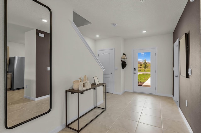 entryway featuring light tile patterned floors and a textured ceiling