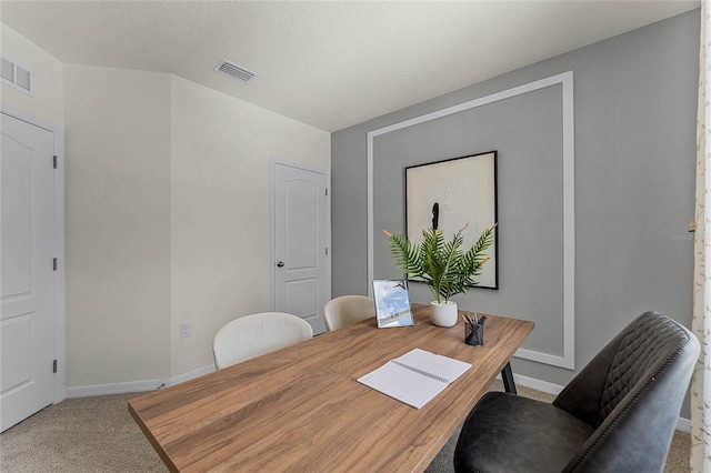 carpeted dining space featuring a textured ceiling