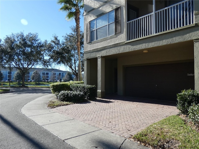 view of property exterior featuring a balcony and a garage