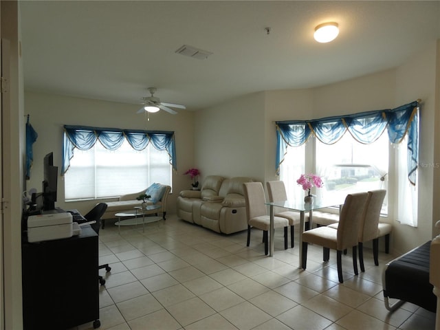 living room with a wealth of natural light, ceiling fan, and light tile patterned flooring