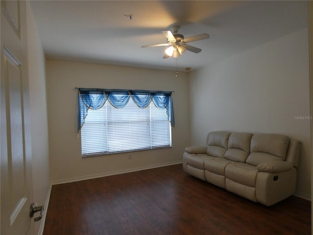 living room featuring dark hardwood / wood-style flooring and ceiling fan