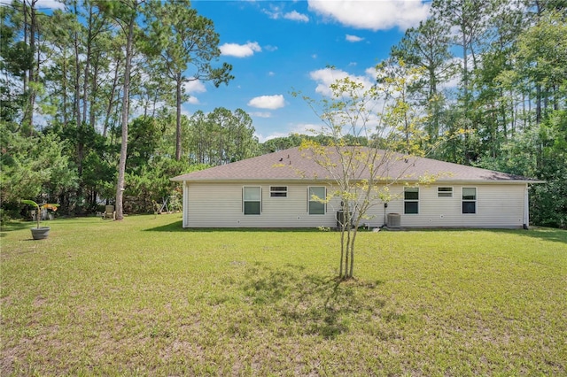 back of house with a lawn and central AC