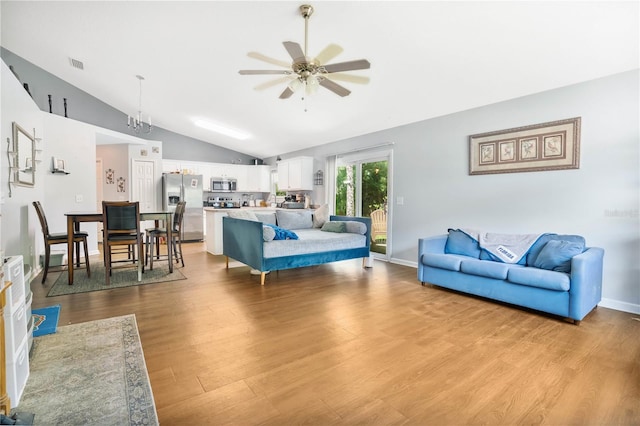 living room with ceiling fan, lofted ceiling, and light hardwood / wood-style flooring