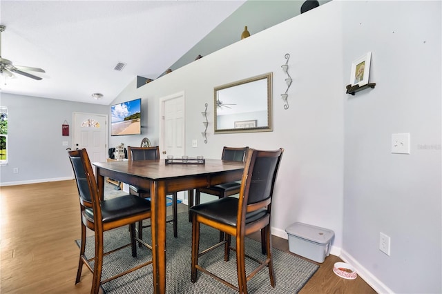 dining area with hardwood / wood-style floors, vaulted ceiling, and ceiling fan