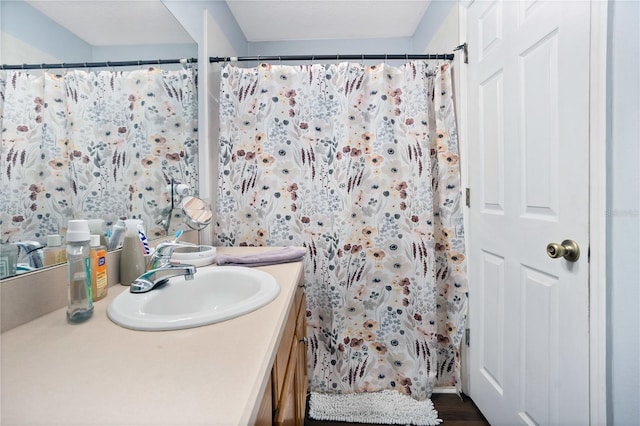 bathroom with curtained shower, hardwood / wood-style floors, and vanity