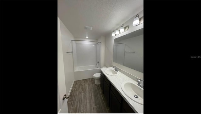 full bathroom featuring vanity, a textured ceiling, toilet, shower / bathing tub combination, and hardwood / wood-style flooring