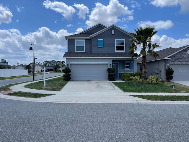 view of front of house with an attached garage, driveway, fence, and a front yard