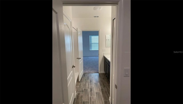 interior space featuring wood finish floors, vanity, and baseboards