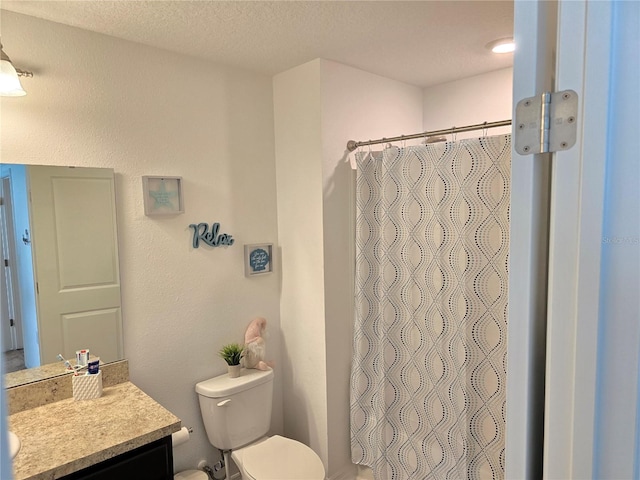 bathroom featuring vanity, toilet, a textured ceiling, and walk in shower