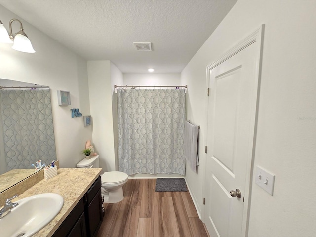 bathroom with vanity, hardwood / wood-style floors, a textured ceiling, and toilet