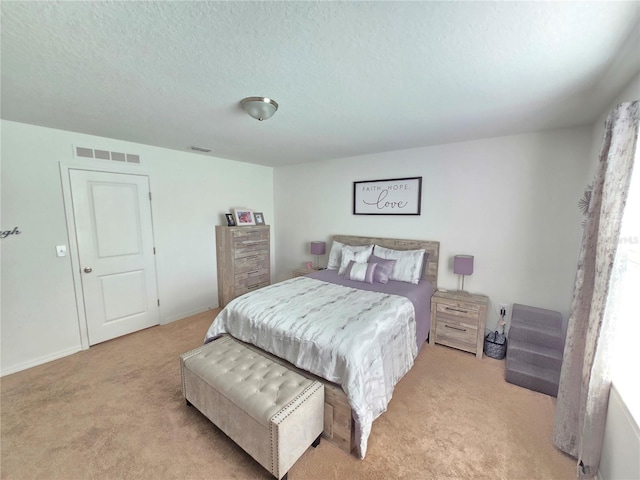 bedroom featuring light carpet and a textured ceiling