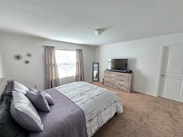 bedroom featuring light carpet and a textured ceiling