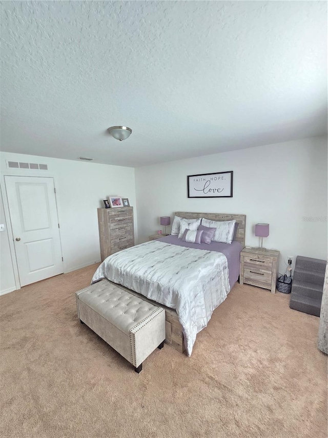 bedroom with carpet floors and a textured ceiling