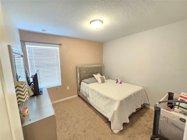 bedroom featuring light colored carpet and a textured ceiling