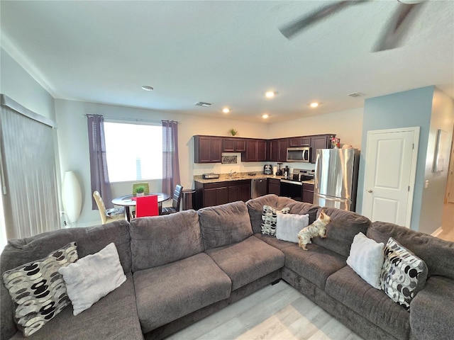 living room featuring sink and light hardwood / wood-style flooring