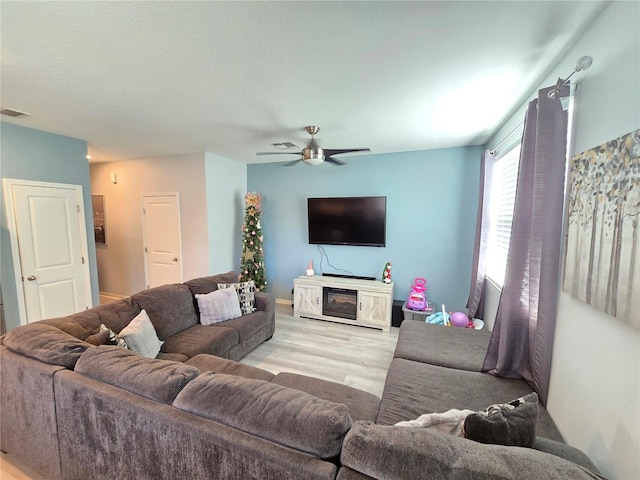 living room featuring ceiling fan and light hardwood / wood-style flooring