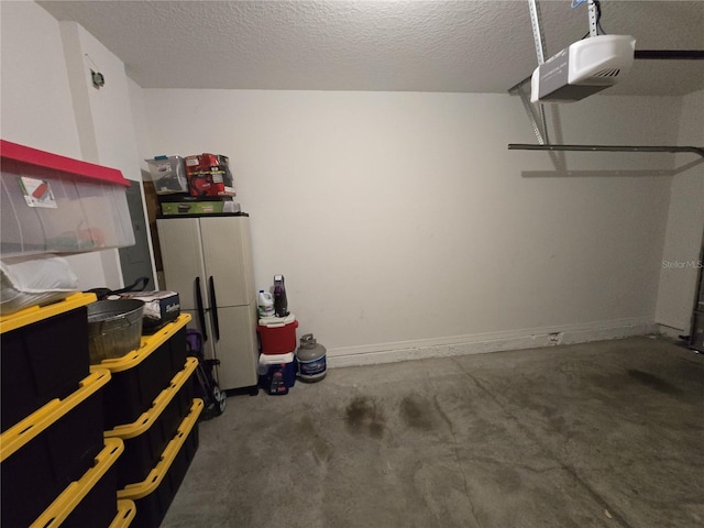 garage with white refrigerator and a garage door opener