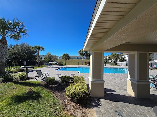 view of pool with a lawn and a patio