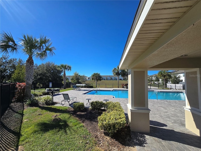 view of pool with a patio area and a yard